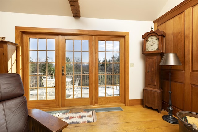 doorway featuring baseboards and light wood-style floors