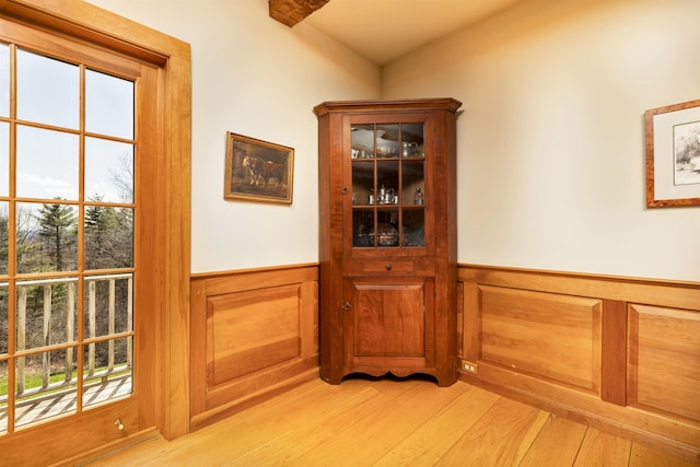 interior space featuring light wood-style flooring and a wainscoted wall