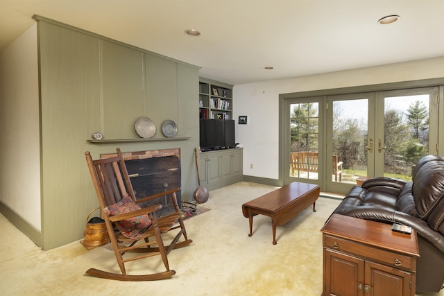 living room with light carpet, built in shelves, french doors, recessed lighting, and baseboards