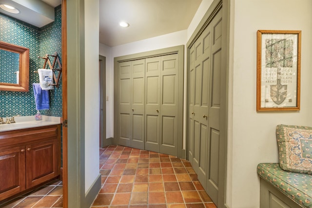 interior space with vanity, recessed lighting, baseboards, and a closet