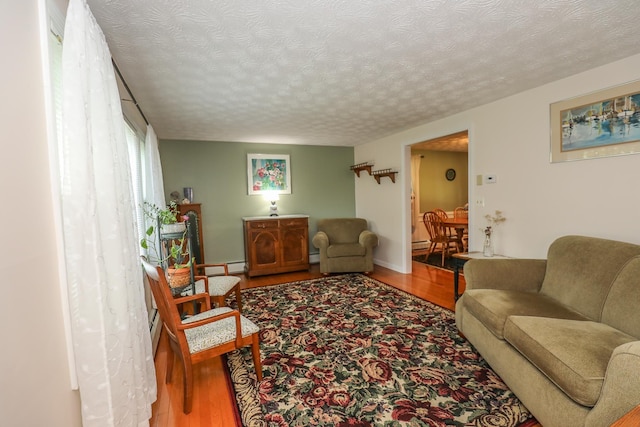 living room with a baseboard radiator, a textured ceiling, and wood finished floors