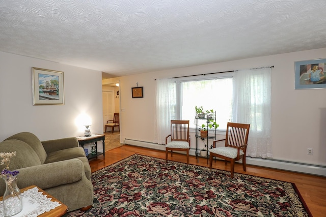 living area with a textured ceiling and wood finished floors