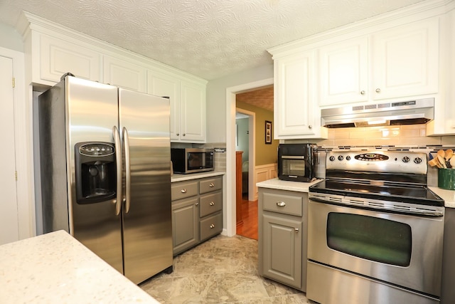 kitchen featuring under cabinet range hood, stainless steel appliances, gray cabinetry, and light countertops