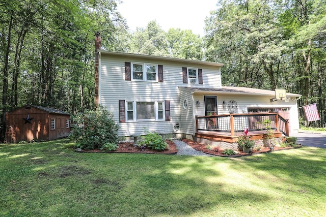view of front of house featuring an outbuilding, a front yard, a storage shed, and a deck