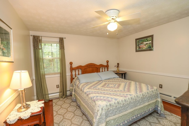 bedroom featuring ceiling fan, a baseboard heating unit, and light wood-type flooring