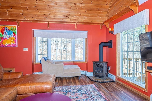 living area with a wood stove, wood finished floors, vaulted ceiling, and wooden ceiling