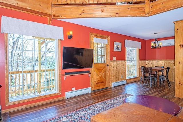 living area featuring a notable chandelier, a wealth of natural light, and baseboard heating