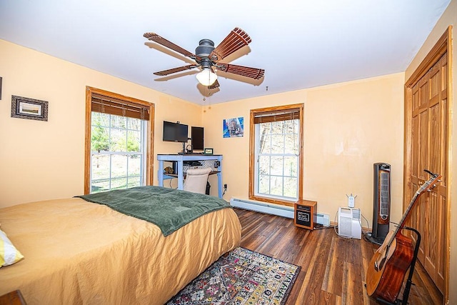 bedroom featuring a ceiling fan, baseboard heating, a baseboard heating unit, and dark wood finished floors