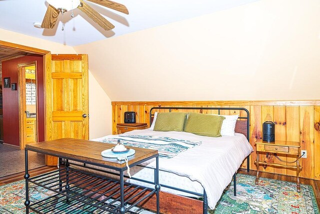bedroom with wooden walls and vaulted ceiling