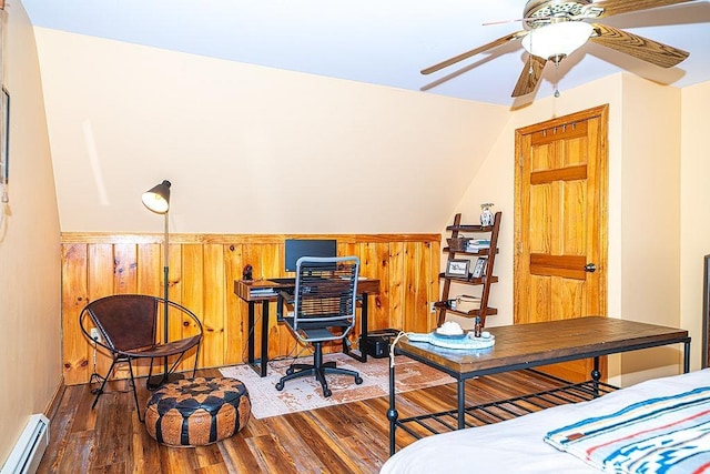 bedroom with a baseboard radiator, wood finished floors, and vaulted ceiling