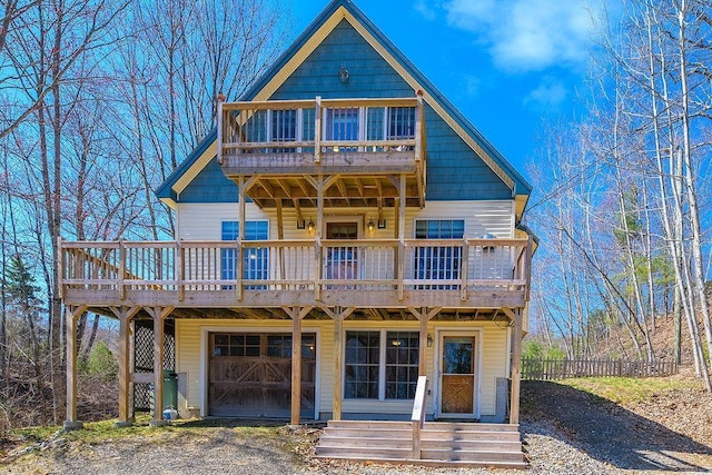 view of front of property featuring fence, an attached garage, a deck, a balcony, and driveway