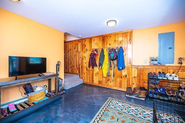 interior space with wood walls, a wainscoted wall, and electric panel