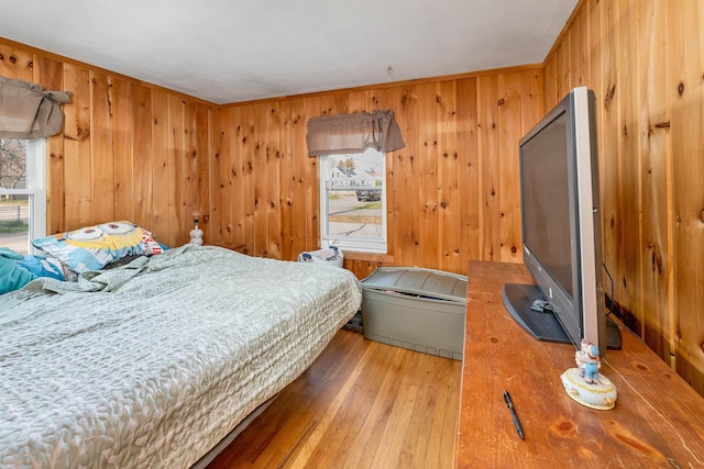 bedroom featuring wood-type flooring and wood walls
