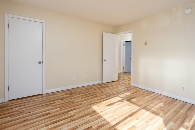 empty room with baseboards and light wood-type flooring