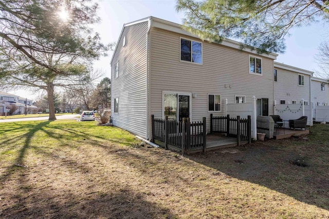 back of property featuring a lawn and a wooden deck