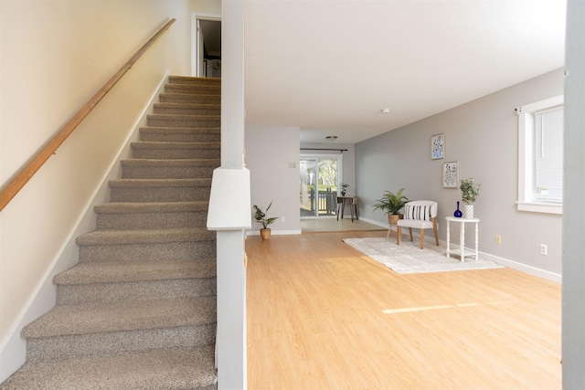 stairs with baseboards and wood finished floors