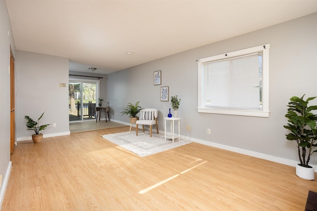 sitting room with baseboards and wood finished floors