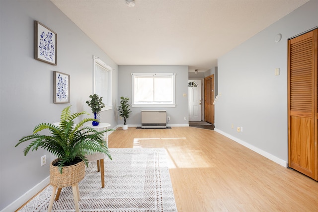 sitting room with baseboards and light wood-type flooring