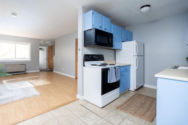 kitchen featuring light countertops, baseboards, blue cabinets, and white appliances