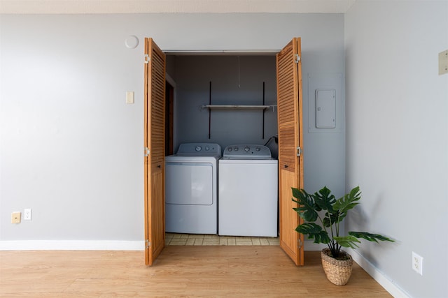 laundry area with separate washer and dryer, laundry area, baseboards, and light wood-type flooring