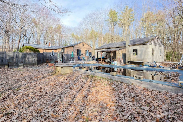rear view of property featuring fence and a chimney