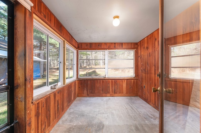 unfurnished sunroom featuring wooden walls