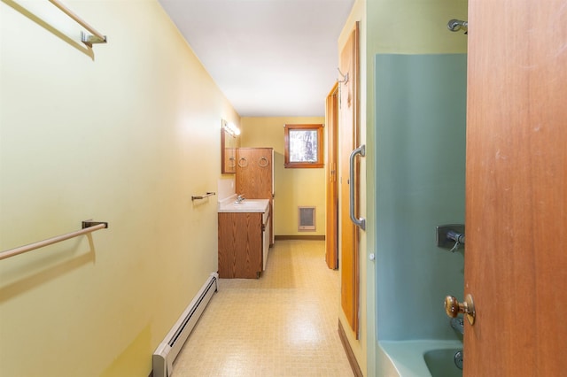 full bath featuring shower / bath combination, baseboard heating, tile patterned floors, baseboards, and vanity