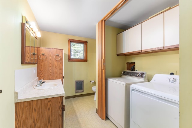 laundry area with laundry area, heating unit, baseboards, washer and clothes dryer, and a sink