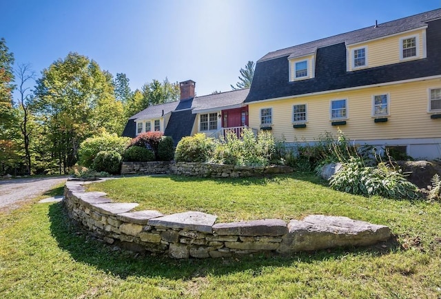 view of front of property featuring a shingled roof, a front lawn, and a gambrel roof