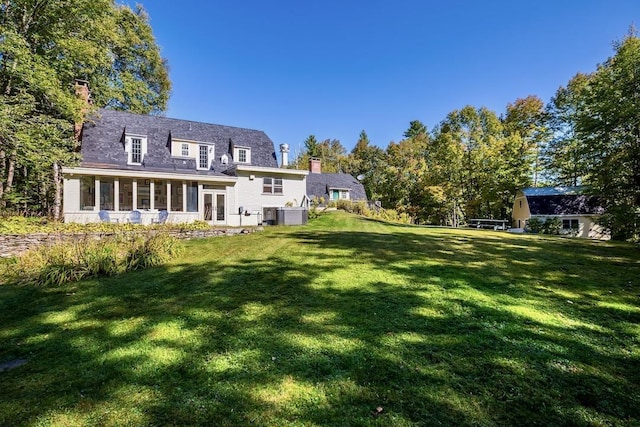 rear view of house featuring a yard and a chimney
