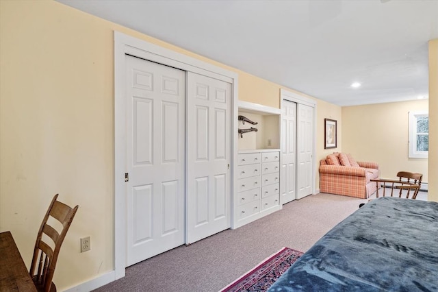 carpeted bedroom featuring recessed lighting and two closets