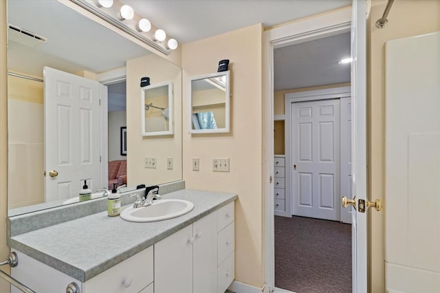 ensuite bathroom featuring vanity, connected bathroom, and visible vents