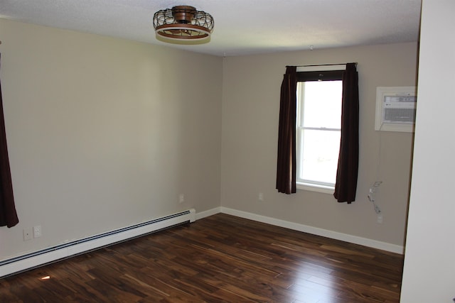 spare room featuring dark wood-type flooring, a wall mounted air conditioner, baseboards, and a baseboard heating unit