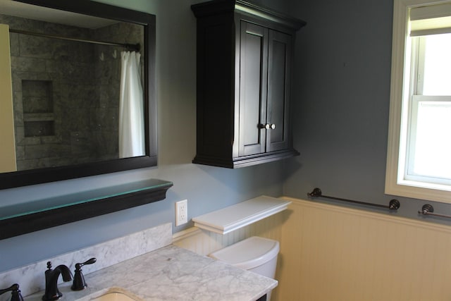 full bathroom featuring vanity, wainscoting, a shower with shower curtain, and toilet