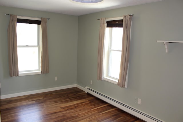 unfurnished room with baseboards, dark wood finished floors, baseboard heating, and a healthy amount of sunlight