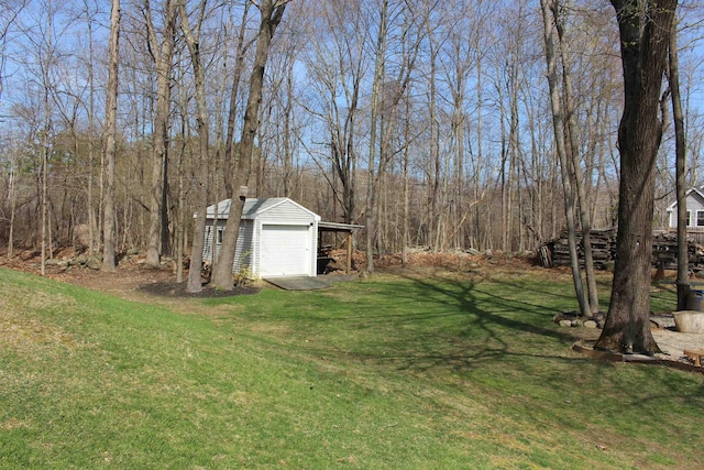 view of yard featuring a detached garage and an outdoor structure