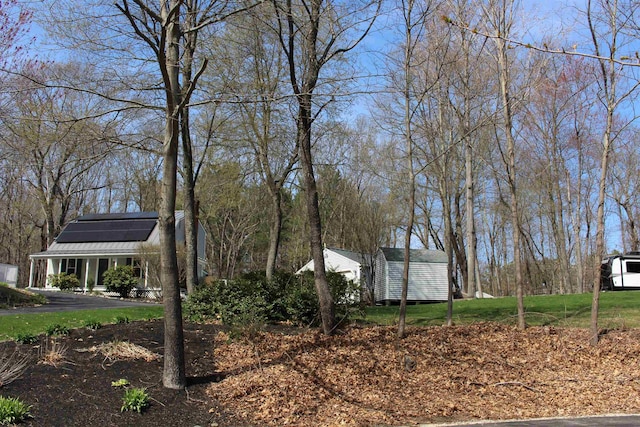 view of yard featuring a storage shed and an outbuilding