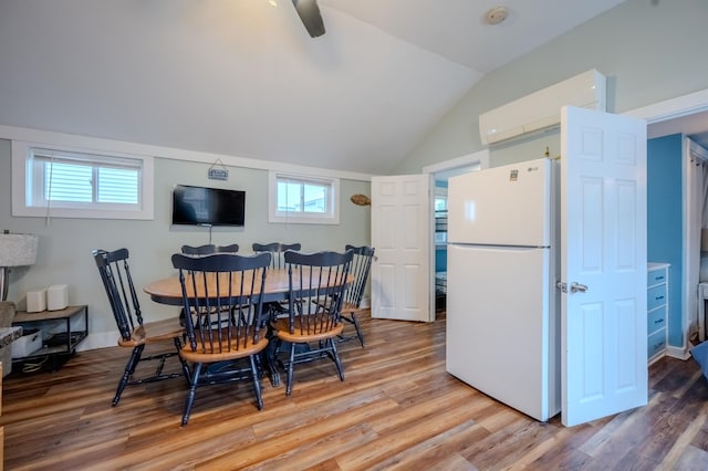 dining area featuring a healthy amount of sunlight, vaulted ceiling, a ceiling fan, and wood finished floors