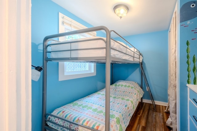 bedroom with baseboards and wood finished floors