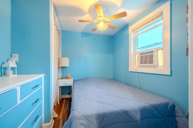 bedroom featuring a ceiling fan, wood finished floors, and cooling unit
