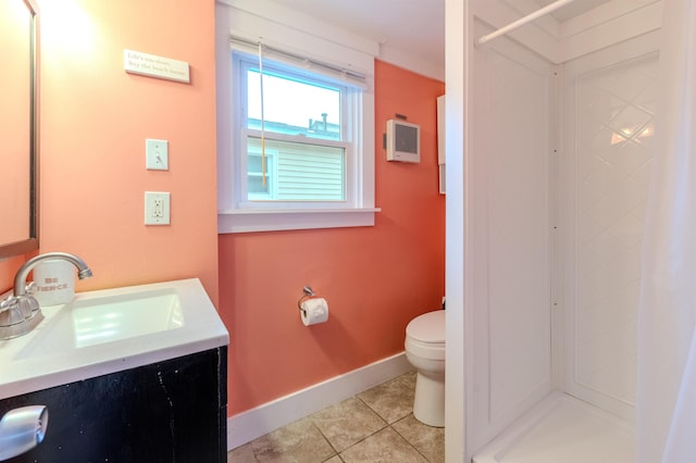 bathroom featuring walk in shower, vanity, toilet, tile patterned floors, and baseboards