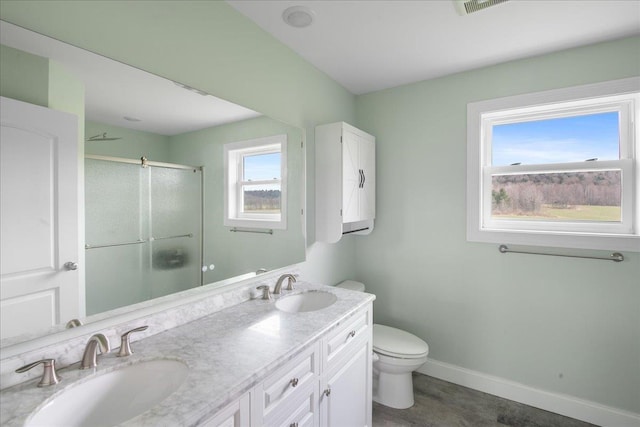 full bathroom with baseboards, a sink, a stall shower, and toilet