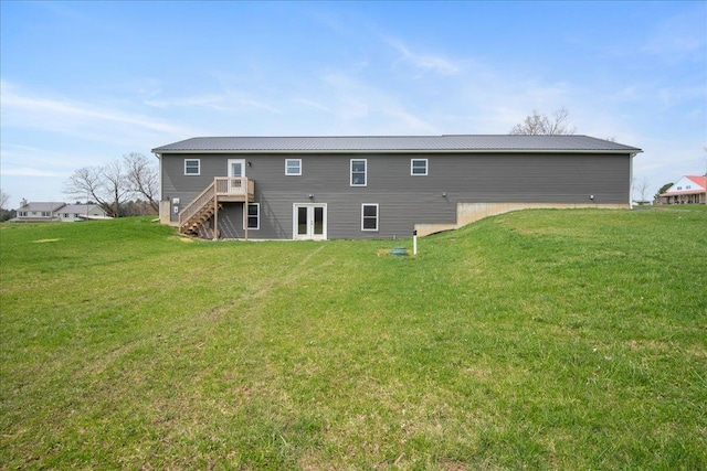 rear view of house with stairway, a yard, a wooden deck, and french doors