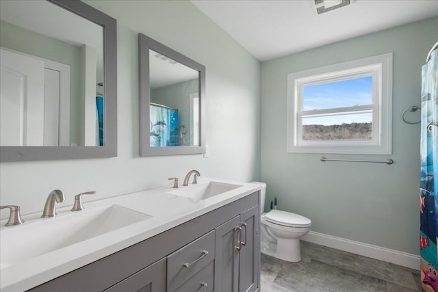 bathroom featuring a sink, baseboards, double vanity, and visible vents