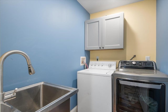 laundry area featuring cabinet space, independent washer and dryer, and a sink
