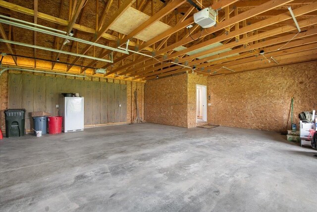 garage with freestanding refrigerator and a garage door opener