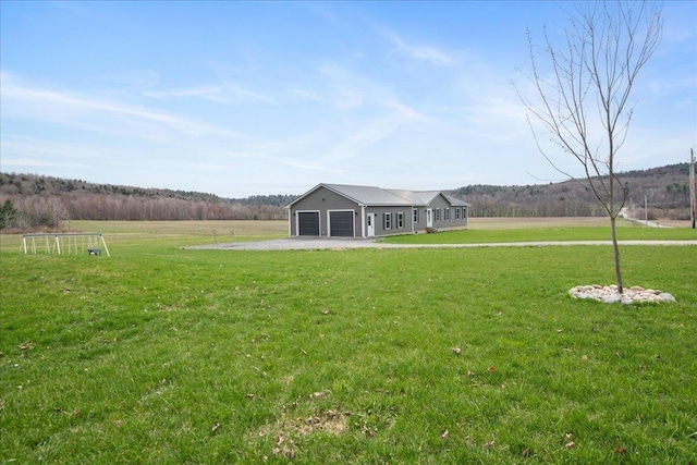 view of yard with a garage and driveway