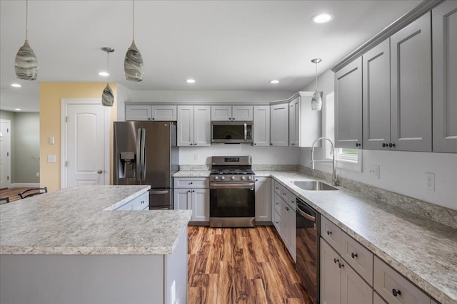 kitchen featuring wood finished floors, beverage cooler, gray cabinets, a sink, and stainless steel appliances