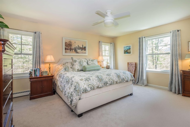bedroom featuring ceiling fan, a baseboard heating unit, light carpet, and baseboards