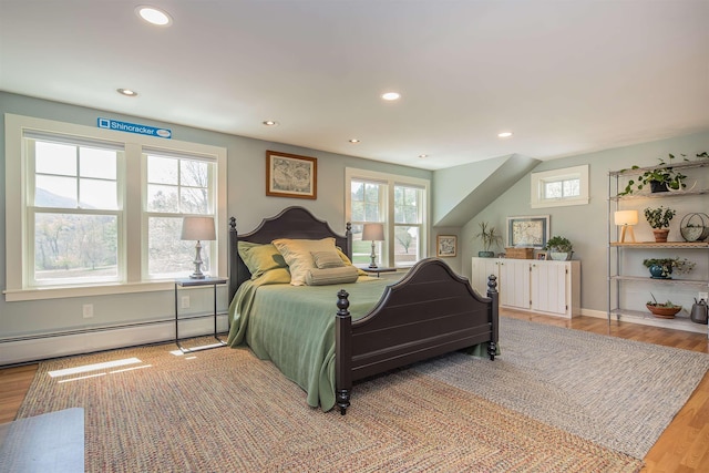 bedroom with light wood-style floors, baseboards, baseboard heating, and recessed lighting